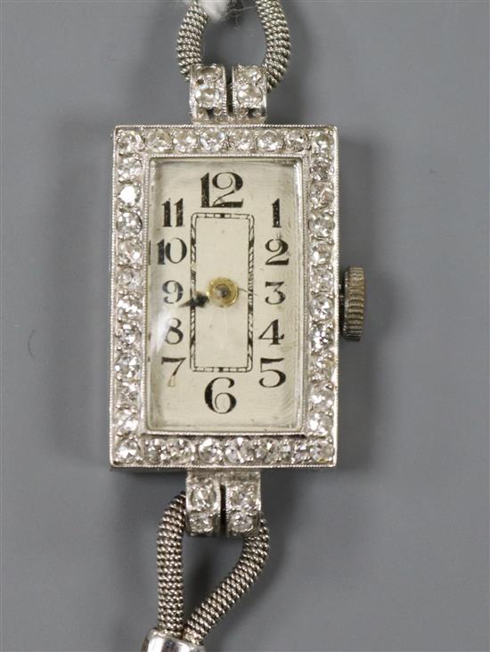 A ladys platinum and diamond set rectangular dial cocktail watch, on a white metal twin strand bracelet.